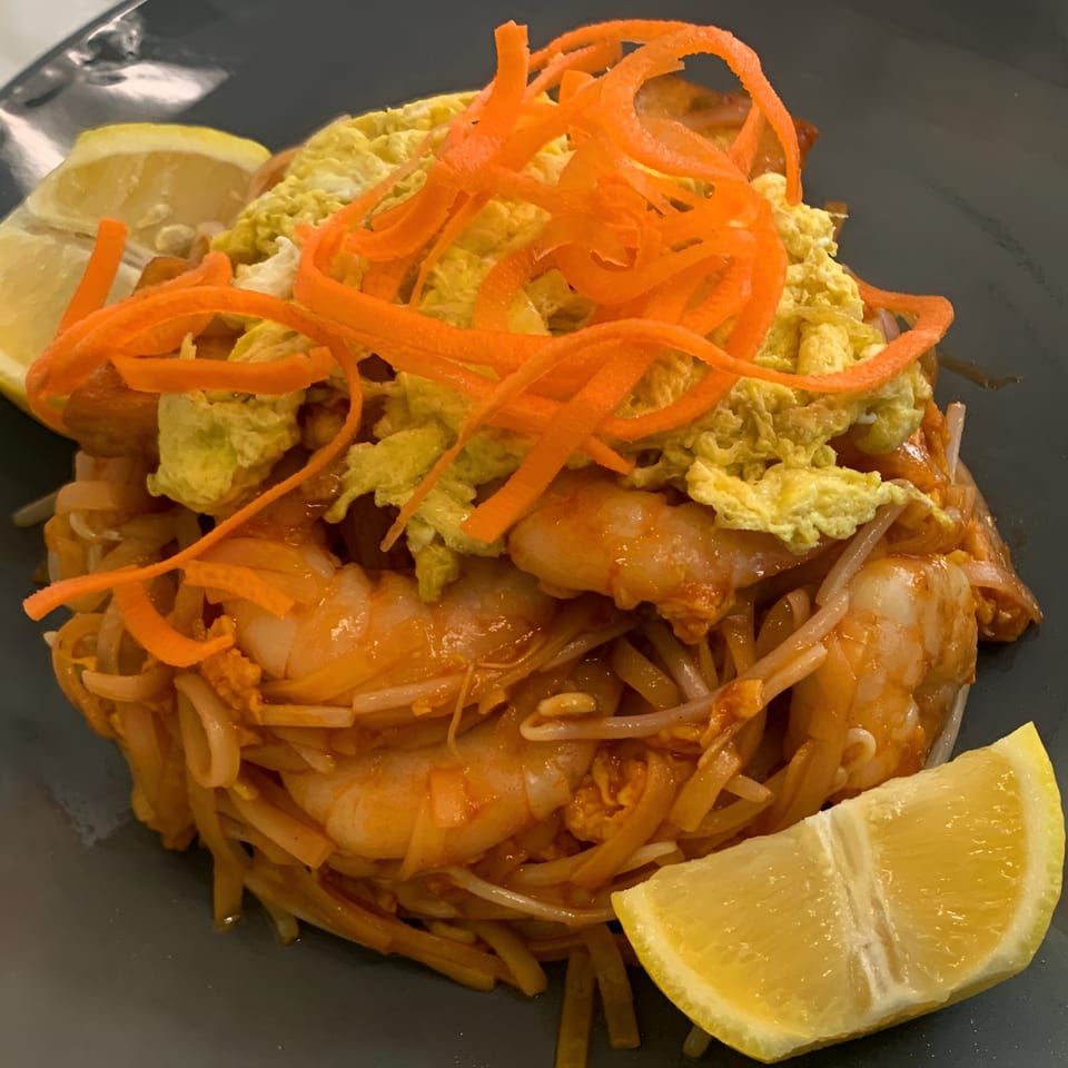 Golden Phoenix Chinese Restaurant's shrimp pad thai with shredded carrots, scrambled egg, and lemon wedges.